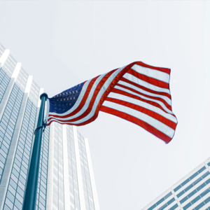 US flag between tall city buildings