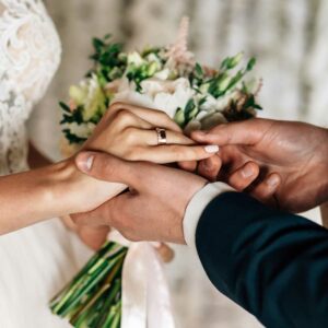 groom putting ring on bride’s hand ,international marriage