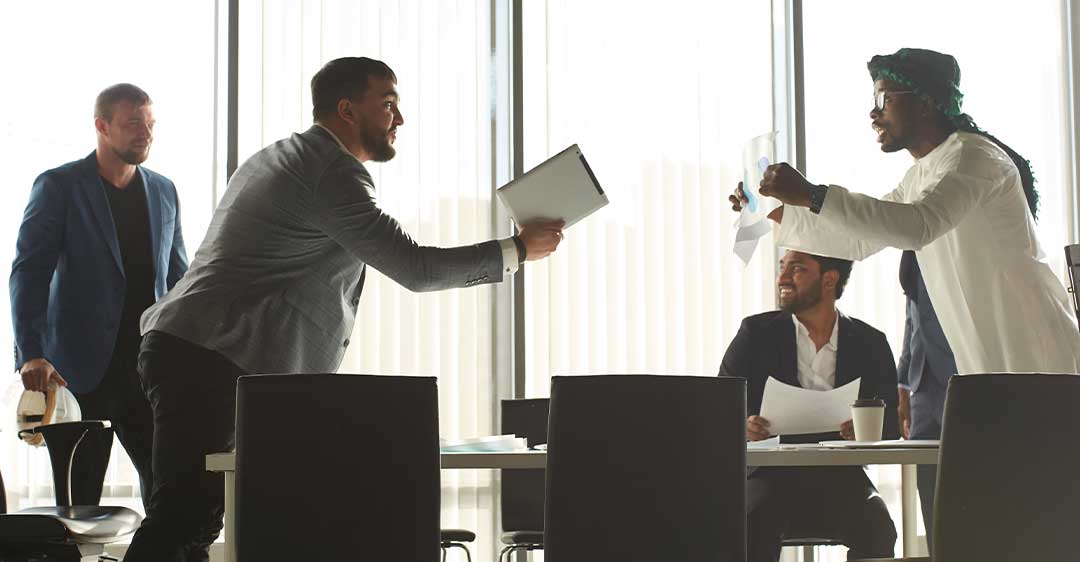 businessmen amidst a dispute around a conference table, resolving LLC member disputes
